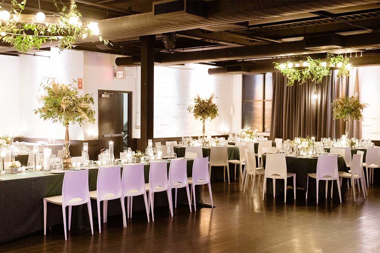 Fall industrial loft wedding in irvington new york with emerald green linens, romantic greenery arrangements and white bellini chairs